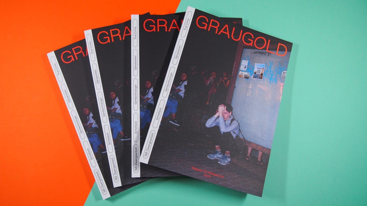 Vier Ausgaben des Magazins Graugold liegen auf einem Hintergrund in den Farben Orange und Türkis.