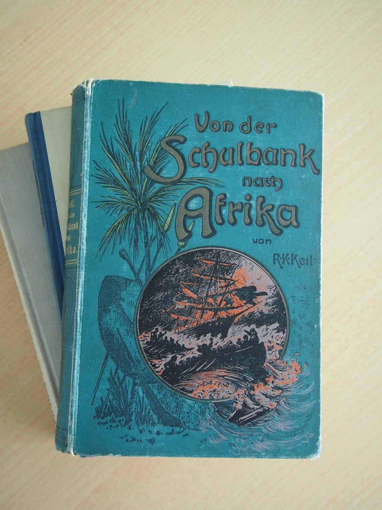 In den 1890er Jahren mehrten sich die Publikationen über die Kolonien. Von Abenteuerbüchern bis hin zu Autobiografien und Sachbüchern popularisierten sie den Kolonialismus. Die meist eurozentristischen Darstellungen wie das 1897 erschienene „Von der Schulbank nach Afrika“ legten ihren Leser:innen nahe, dass im fernen Afrika spannende Erlebnisse und Erfahrungen auf sie warteten. (Foto: Cantauw) In den 1890er Jahren mehrten sich die Publikationen über die Kolonien. Von Abenteuerbüchern bis hin zu Autobiografien und Sachbüchern popularisierten sie den Kolonialismus. Die meist eurozentristischen Darstellungen wie das 1897 erschienene „Von der Schulbank nach Afrika“ legten ihren Leser:innen nahe, dass im fernen Afrika spannende Erlebnisse und Erfahrungen auf sie warteten. (Foto: Cantauw)
